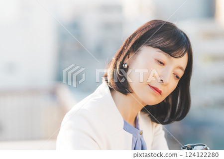 A middle-career woman thinking alone while facing a wall A middle-career woman thinking alone while facing a wall 124122280