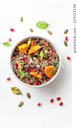 autumn quinoa salad with roasted pumpkin, pumpkin seeds, and pomegranate served on a white background with a tiny focal point and vast clean negative space concept of seasonal healthy eating autumn quinoa salad with roasted pumpkin, pumpkin seeds, and pomegranate served on a white background with a tiny focal point and vast clean negative space concept of seasonal healthy eating 124123116