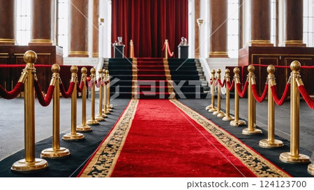 A luxurious red carpet leading up to a grand staircase, framed by golden stanchions and velvet ropes. The elegant setting evokes a sense of glamour, perfect for awards, events, and VIP occasions 124123700