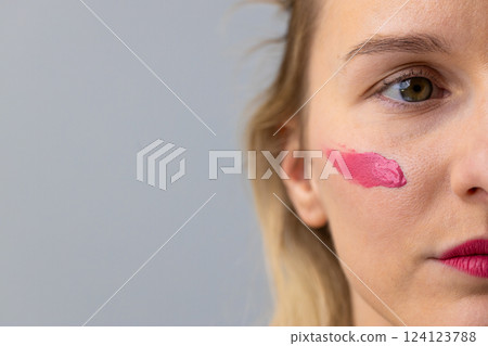 Close-Up of a Young Woman with Pink Lipstick Applying Makeup to Her Cheek for a Chic, Artistic Look and Embracing Modern Beauty Trends Close-Up of a Young Woman with Pink Lipstick Applying Makeup to Her Cheek for a Chic, Artistic Look and Embracing Modern Beauty Trends 124123788