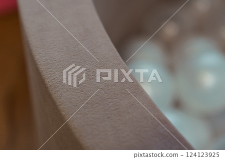 Close-Up View of Soft Textured Fabric Container Edge with Blurred Background of Translucent Objects 124123925