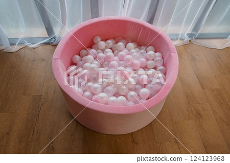 Pink Round Ball Pit with White and Pink Plastic Balls on Wood Floor by Transparent Curtain Pink Round Ball Pit with White and Pink Plastic Balls on Wood Floor by Transparent Curtain 124123968