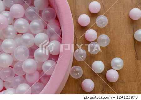 Pink and White Ball Pit with Scattered Playful Balls on Wooden Floor Pink and White Ball Pit with Scattered Playful Balls on Wooden Floor 124123978