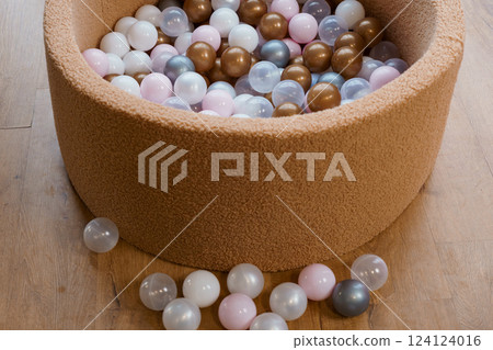 Beige Soft Foam Ball Pit Filled with Brown, Pink, White, and Transparent Plastic Balls on Wooden Floor 124124016