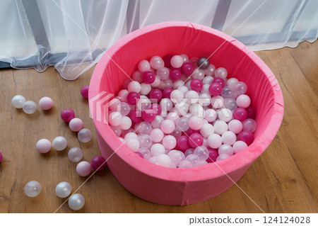 Pink Ball Pit with Colorful Plastic Balls on Wooden Floor Indoors Pink Ball Pit with Colorful Plastic Balls on Wooden Floor Indoors 124124028