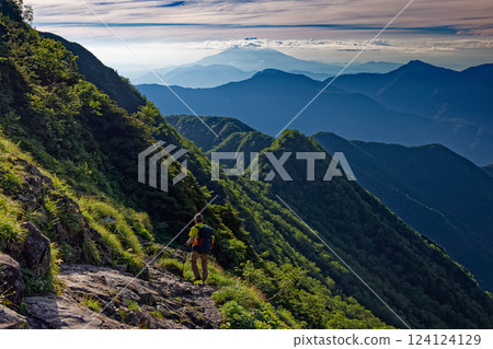 Climbers walking along the eastern ridge of Akaishi-dake in the Southern Alps and Mount Fuji Climbers walking along the eastern ridge of Akaishi-dake in the Southern Alps and Mount Fuji 124124129