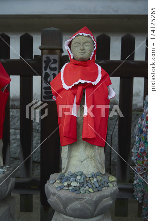 戴著紅色頭巾的地藏菩薩像。石像。日本寺廟風景 戴著紅色頭巾的地藏菩薩像。石像。日本寺廟風景 124125265