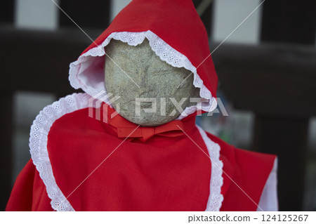Jizo statue wearing a red hood. Stone statue. Scenery of a Japanese temple Jizo statue wearing a red hood. Stone statue. Scenery of a Japanese temple 124125267