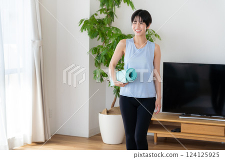 Woman doing yoga in the living room 124125925
