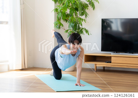 Woman doing yoga in the living room 124126161