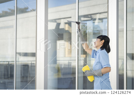 一名 50 多歲的女清潔工正在清潔窗戶 124126274