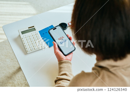 操作智慧型手機的高級婦女 NISAvsiDeCo 124126340