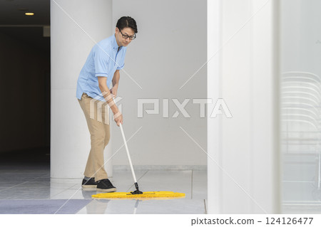 大樓清潔圖片:一名 40 多歲的男性清潔人員正在拖地 大樓清潔圖片:一名 40 多歲的男性清潔人員正在拖地 124126477