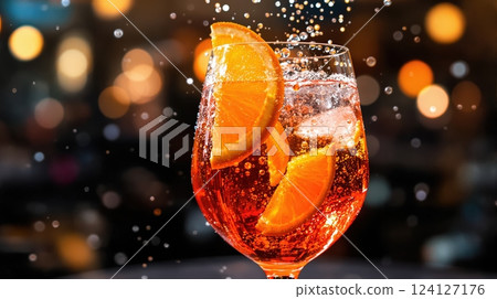 Aperol spritz cocktail with fresh orange slices in a lively bar setting 124127176