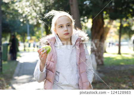 Cute child girl walking in city park outdoors. Healthy playful kid portrait Cute child girl walking in city park outdoors. Healthy playful kid portrait 124128983