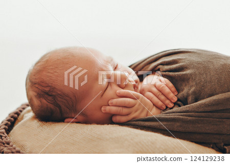 A newborn baby is wrapped in diapers with a wool cap in a basket. Swaddling, maternity hospital, family, ivf, life planning, parenting. A mother's love for her child. Baby food. High quality photo A newborn baby is wrapped in diapers with a wool cap in a basket. Swaddling, maternity hospital, family, ivf, life planning, parenting. A mother's love for her child. Baby food. High quality photo 124129238