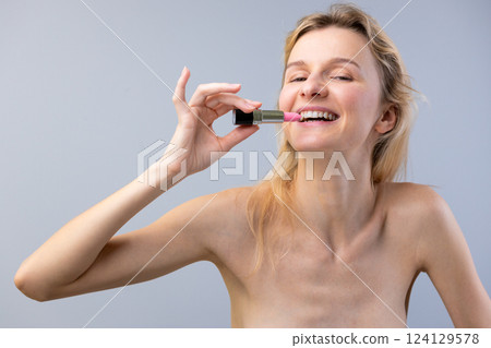 A Bright Smile: Capturing Joy and Beauty in a Playful Makeup Moment Featuring a Woman Holding Pink Lipstick A Bright Smile: Capturing Joy and Beauty in a Playful Makeup Moment Featuring a Woman Holding Pink Lipstick 124129578