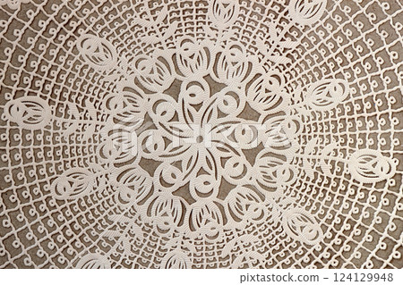 Cream craft lace doily, vintage textured background. Vintage lace doily with intricate cutout patterns on a neutral background. Delicate and classic decorative textile for elegant designs 124129948