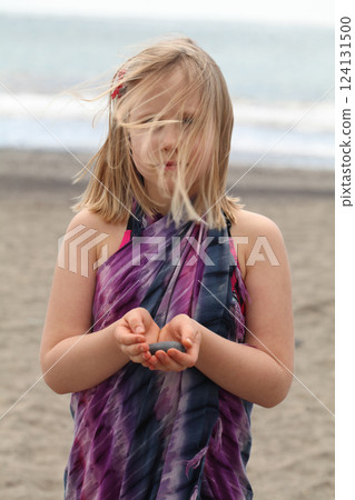 Outdoors portrait of cute young child girl on the sea beach in windy day Outdoors portrait of cute young child girl on the sea beach in windy day 124131500