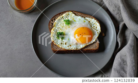 Sandwich of black bread with fried egg on gray plate, home food, home breakfast 124132839