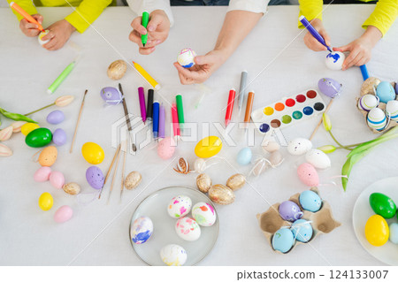 Happy Easter. Little girls grandmother hands painting eggs enjoying time together. Happy family preparing for Easter. Table with colorful painting eggs decorations. Spring Christian festival tradition Happy Easter. Little girls grandmother hands painting eggs enjoying time together. Happy family preparing for Easter. Table with colorful painting eggs decorations. Spring Christian festival tradition 124133007