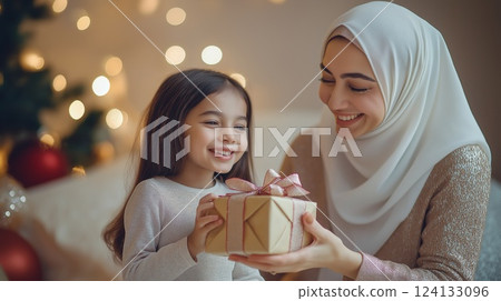 A loving mother and daughter exchanging a gift 124133096