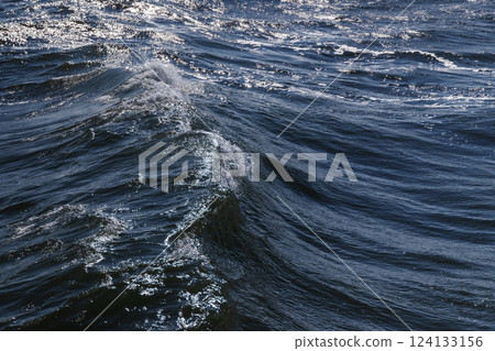 Glistening ocean waves gently crest under the sunlight, evoking tranquility Glistening ocean waves gently crest under the sunlight, evoking tranquility 124133156