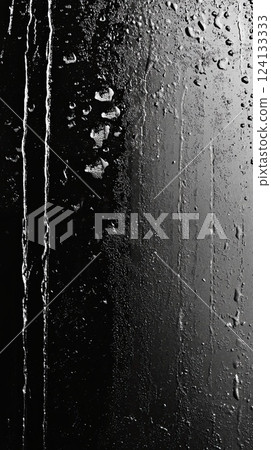 wet and textured black surface with water droplets and streaks, creating a dramatic contrast  124133333