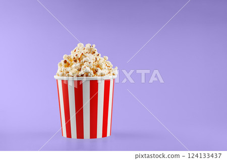 Classic red striped popcorn cardboard cup on Purple, violet background Classic red striped popcorn cardboard cup on Purple, violet background 124133437