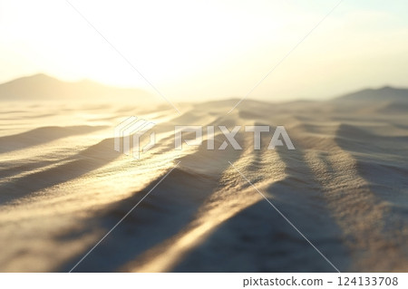 Golden sunrise illuminating desert sand dunes 124133708