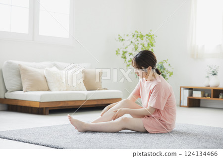 一位穿著睡衣做身體照顧的女人 一位穿著睡衣做身體照顧的女人 124134466