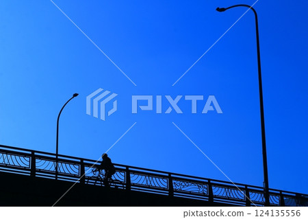 A bicycle crossing an overpass under the deep blue sky 124135556