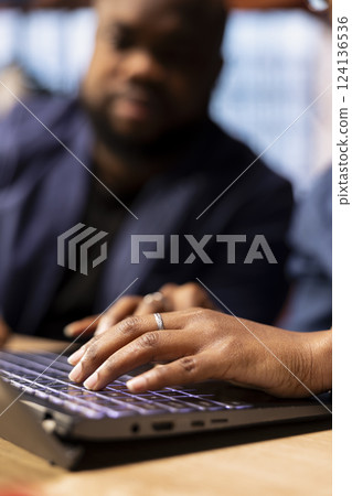 African American man and woman sits at a stylish home office, brainstorming ideas for their digital business, using modern technology to improve communication and project efficiency. 124136536