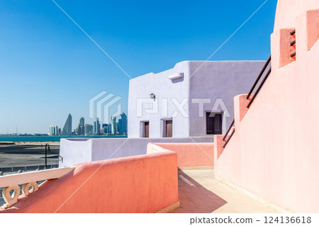 Colorful Mina village district street with arab traditional shaped buildings and modern downtown in the background, Doha, Qatar 124136618