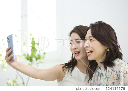 一位時尚的母女一起看智慧型手機 124136676