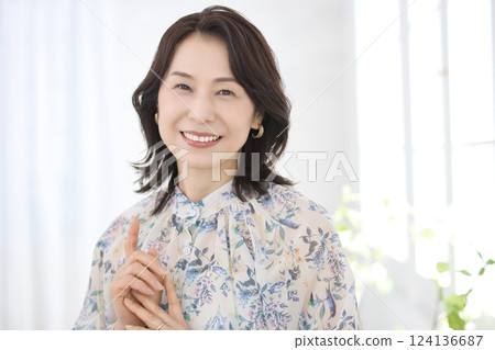 一位身穿花襯衫、微笑的中年婦女 一位身穿花襯衫、微笑的中年婦女 124136687