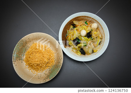 Crispy, hard-baked noodles topped with stir-fried vegetables and a thick sauce make this a perfect dish. Crispy, hard-baked noodles topped with stir-fried vegetables and a thick sauce make this a perfect dish. 124136750