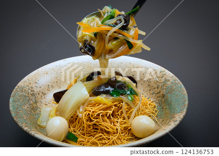 Crispy, hard-baked noodles topped with stir-fried vegetables and a thick sauce make this a perfect dish. Crispy, hard-baked noodles topped with stir-fried vegetables and a thick sauce make this a perfect dish. 124136753