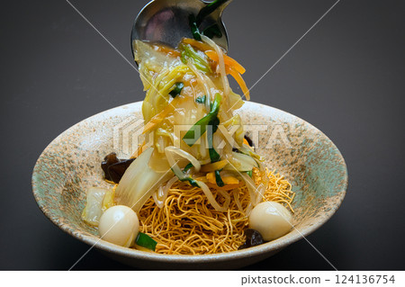 Crispy, hard-baked noodles topped with stir-fried vegetables and a thick sauce make this a perfect dish. Crispy, hard-baked noodles topped with stir-fried vegetables and a thick sauce make this a perfect dish. 124136754