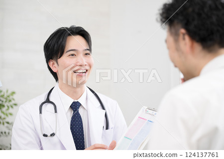 特寫鏡頭:一位微笑的醫生向病人解釋體檢諮詢和測試結果 特寫鏡頭:一位微笑的醫生向病人解釋體檢諮詢和測試結果 124137761