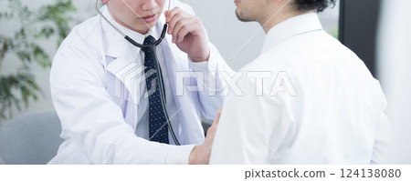 Doctor listening to the patient's heart and lungs, no face 124138080