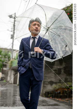 A man holding an umbrella on a rainy day A man holding an umbrella on a rainy day 124139383