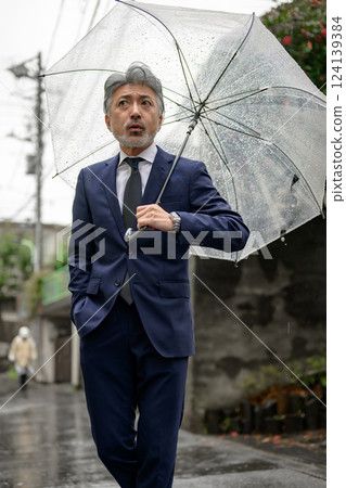 A man holding an umbrella on a rainy day A man holding an umbrella on a rainy day 124139384
