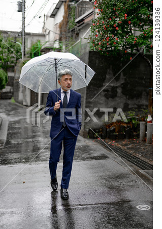 A man holding an umbrella on a rainy day 124139386