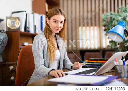 Young confident businesswoman works at a computer in the office Young confident businesswoman works at a computer in the office 124139633