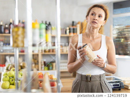 Adult woman choosing beans in grocery store Adult woman choosing beans in grocery store 124139719
