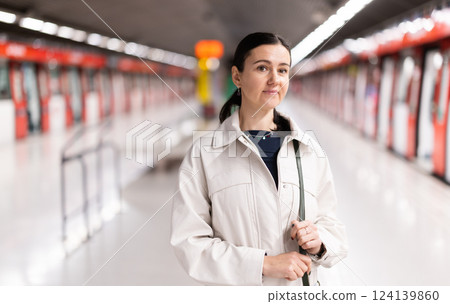 Girl is standing on metro platform station, waiting for transport to arrive Girl is standing on metro platform station, waiting for transport to arrive 124139860