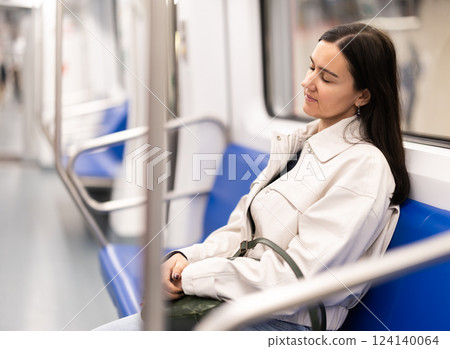 Woman passenger fell asleep in subway car. Long moving home after work 124140064