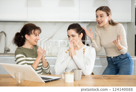 Three happy middle-aged woman expressing joy for winning in the kitchen 124140088