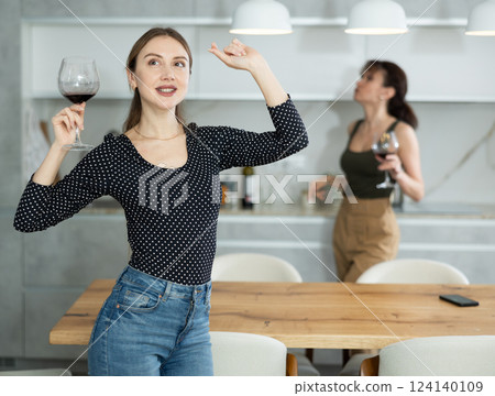 Woman enthusiastically dances in kitchen and enjoys encouraging news. 124140109